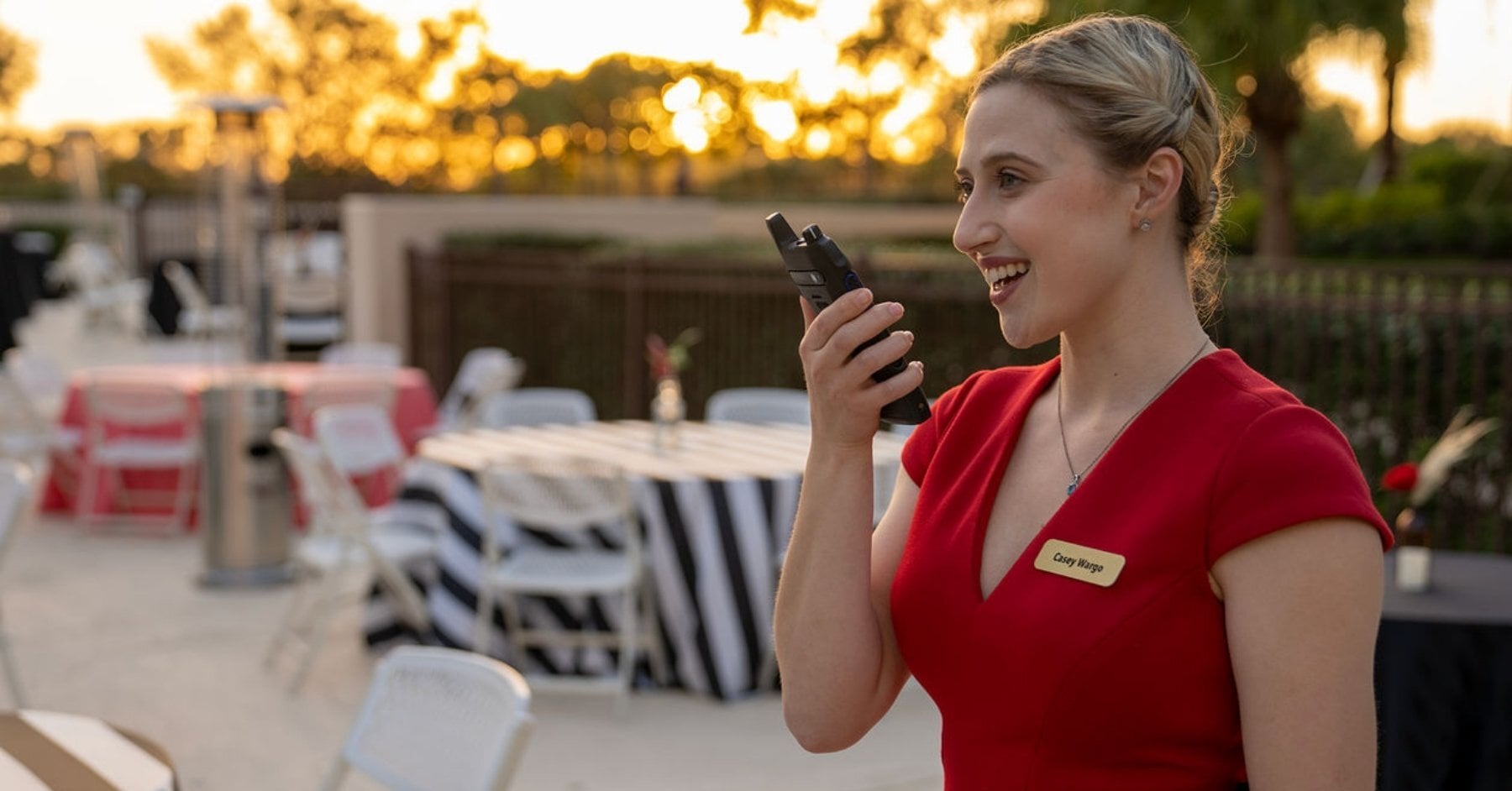 Event coordinator using a Motorola two-way radio at a large outdoor festival to manage staff communication
