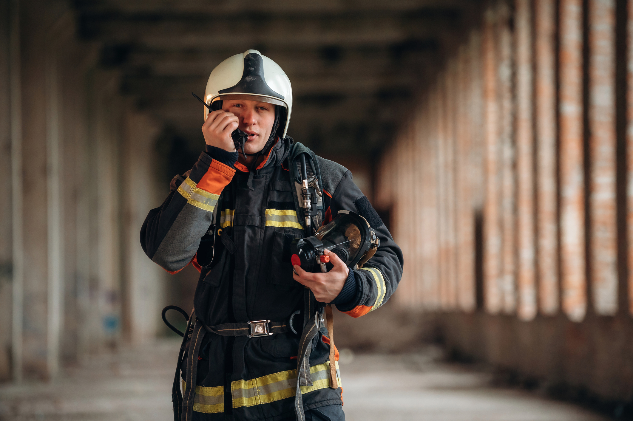 firefighter using handheld radio inside commercial building during emergency response
